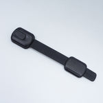 Black plastic strap with a buckle on a light gray background